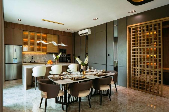 Une salle à manger et cuisine ouvertes au design luxueux alliant bois foncé, gris anthracite et dorés pour choisir les couleurs idéales d'un intérieur haut de gamme.