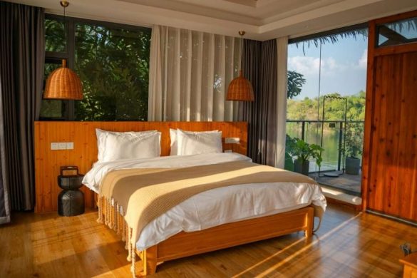 Chambre luxueuse avec tête de lit et mobilier en bois naturel.