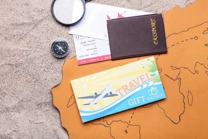 Un passeport et un bon cadeau posés sur une carte géographique, parfaits pour préparer son journal de bord de voyage.